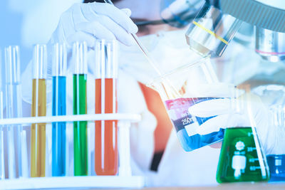 Close-up of scientist holding liquid in laboratory