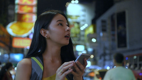 Young woman using mobile phone at night