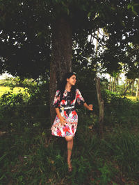 Young woman standing on tree trunk