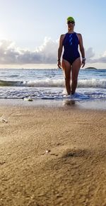 Rear view of woman on beach against sky