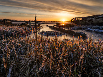 Scenic view of frozen lake against sky during sunset