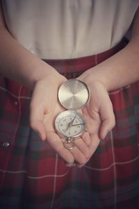 Midsection of woman holding pocket clock