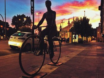 Rear view of man riding bicycle on city street