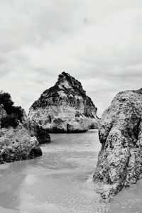 Rock formations by sea against sky