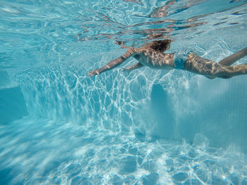 Low section of woman swimming in pool