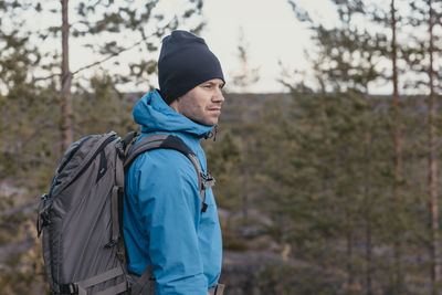 Young man looking away in forest