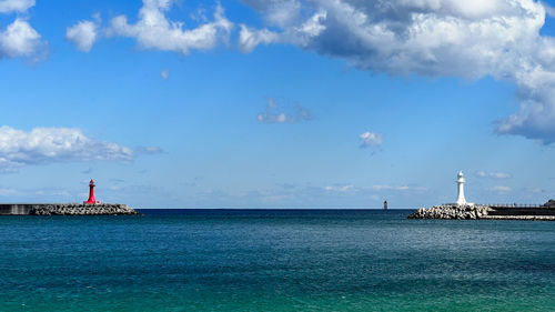 Lighthouse by sea against sky