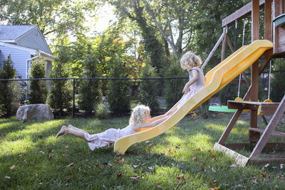 Sisters playing on slide at playground