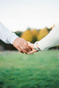 Midsection of couple holding hands