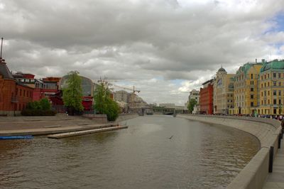 River amidst buildings in city against sky