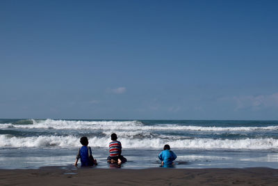 People on beach against sky