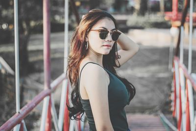 Portrait of young woman wearing sunglasses standing outdoors