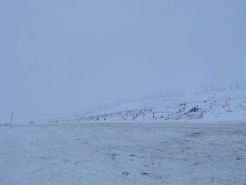 Scenic view of snow covered land against clear sky