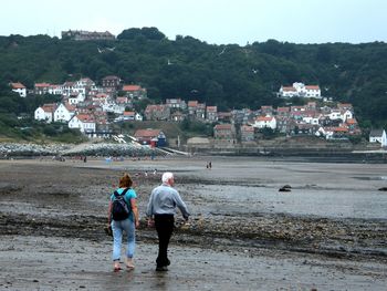 Couple walking standing on beach against sky