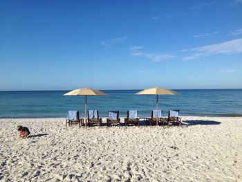 Deck chairs with sunshades overlooking sea