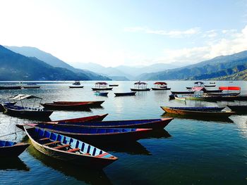 Boats moored in sea against sky