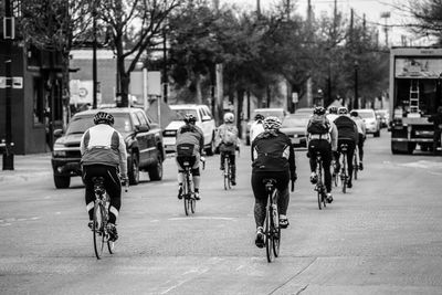 Rear view of bicycling on road