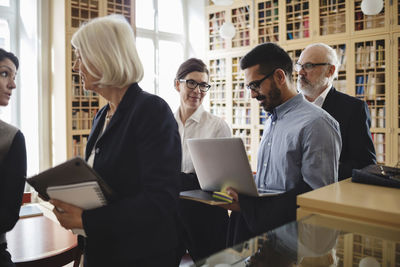 Lawyers discussing while walking in library