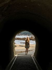 Rear view of woman seen through tunnel