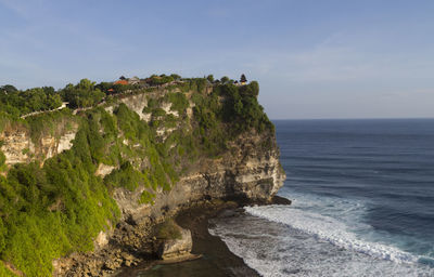 Scenic view of cliff by sea against sky