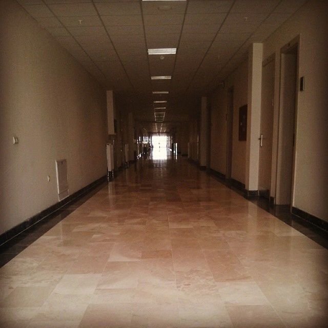 indoors, corridor, the way forward, tiled floor, architecture, built structure, flooring, illuminated, ceiling, empty, diminishing perspective, lighting equipment, tile, absence, wall - building feature, narrow, walkway, floor, vanishing point, building