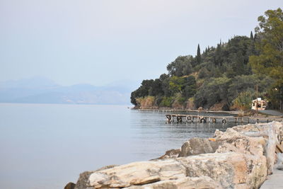 Scenic view of rocks by sea against sky