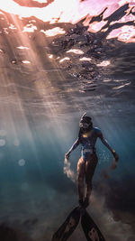 Rear view of man jumping in sea