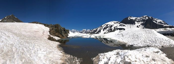 Scenic view of snowcapped mountains against clear blue sky