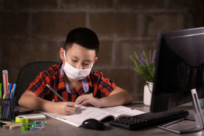 Boy writing on table