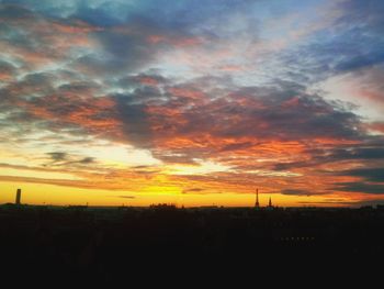 Silhouette landscape against dramatic sky during sunset