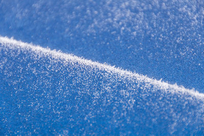Frost texture over blue metal. abstract winter background