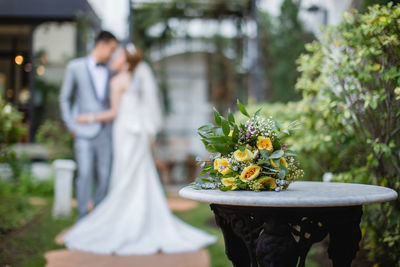 Close-up of couple with bouquet on table