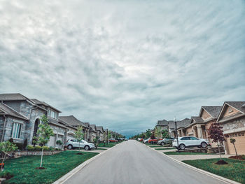 Road amidst buildings against sky