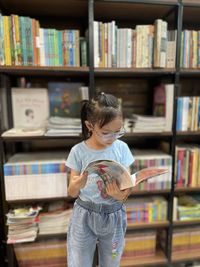 Side view of boy standing in library