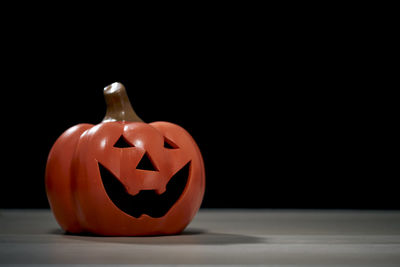 Close-up of pumpkin on table against black background