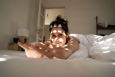 Portrait of man lying down on bed at home