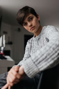 Portrait of young woman standing against wall