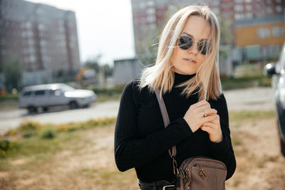 Portrait of smiling young woman standing in city