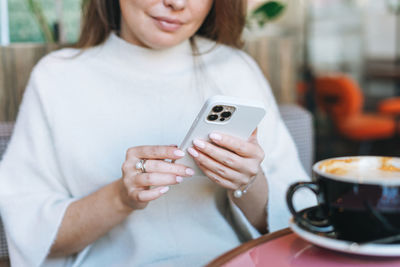 Midsection of man holding coffee cup