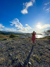 Rear view of woman standing on field against sky on the margarita island in venezuela 