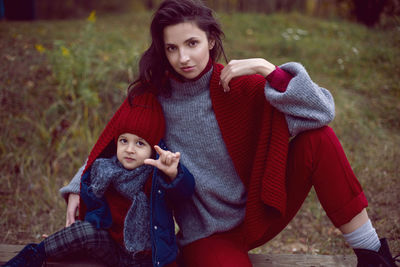 Mom and son sitting on a street bench in the fall