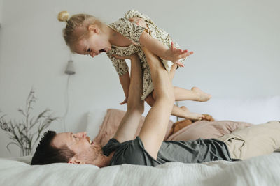 Side view of young couple lying on bed