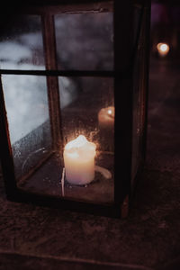 Close-up of lit candle in glass