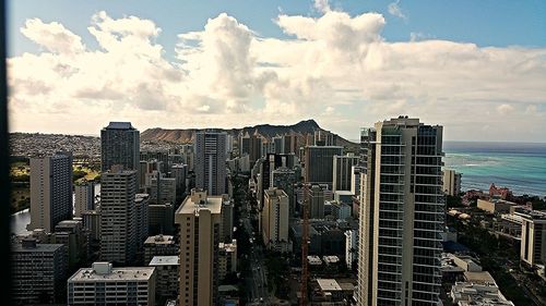 View of cityscape against cloudy sky