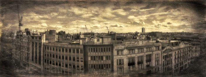Buildings in city against cloudy sky