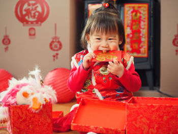 Portrait of cute girl in traditional clothing with decoration sitting at home