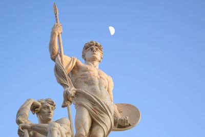 Low angle view of angel statue against clear blue sky