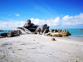 Scenic view of rocks on beach against sky