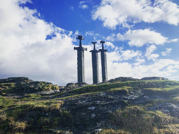 Cross on mountain against sky