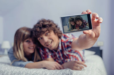 Portrait of smiling young woman using mobile phone at home